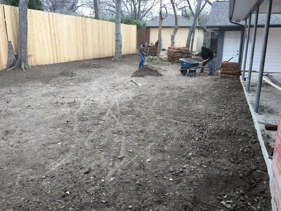 Workers preparing residential soil before sod installation