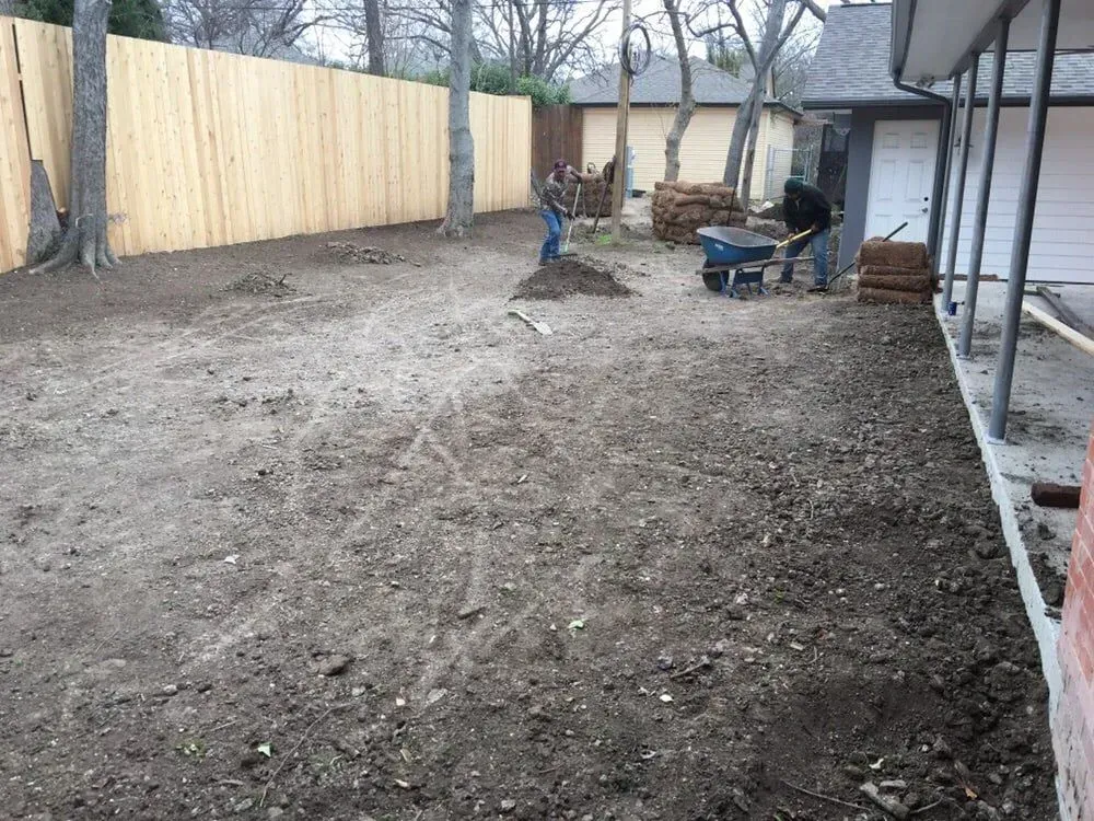 Workers preparing residential soil before sod installation